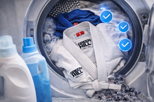 Judogi Green Hill bianco e blu in lavatrice con detergenti e simboli di lavaggio corretto.